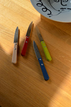 Roger Orfevre red-handled herb knife with wooden shaft, showcasing sharp blade and ergonomic design for kitchen tasks.