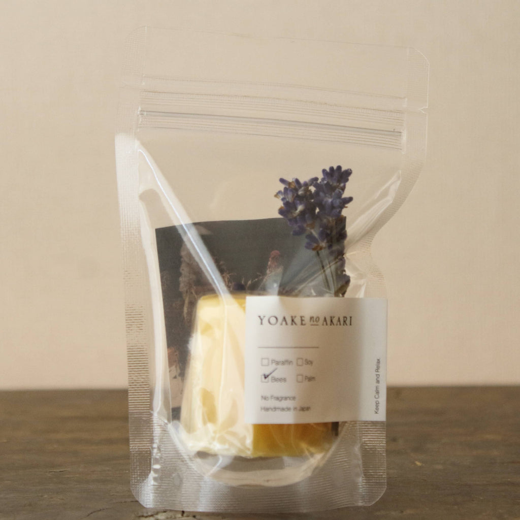Du ser en japansk YNA Bees Wax Candle Canelé lavet af bivoks, med en gylden, naturlig farve og blød lysstyrke.