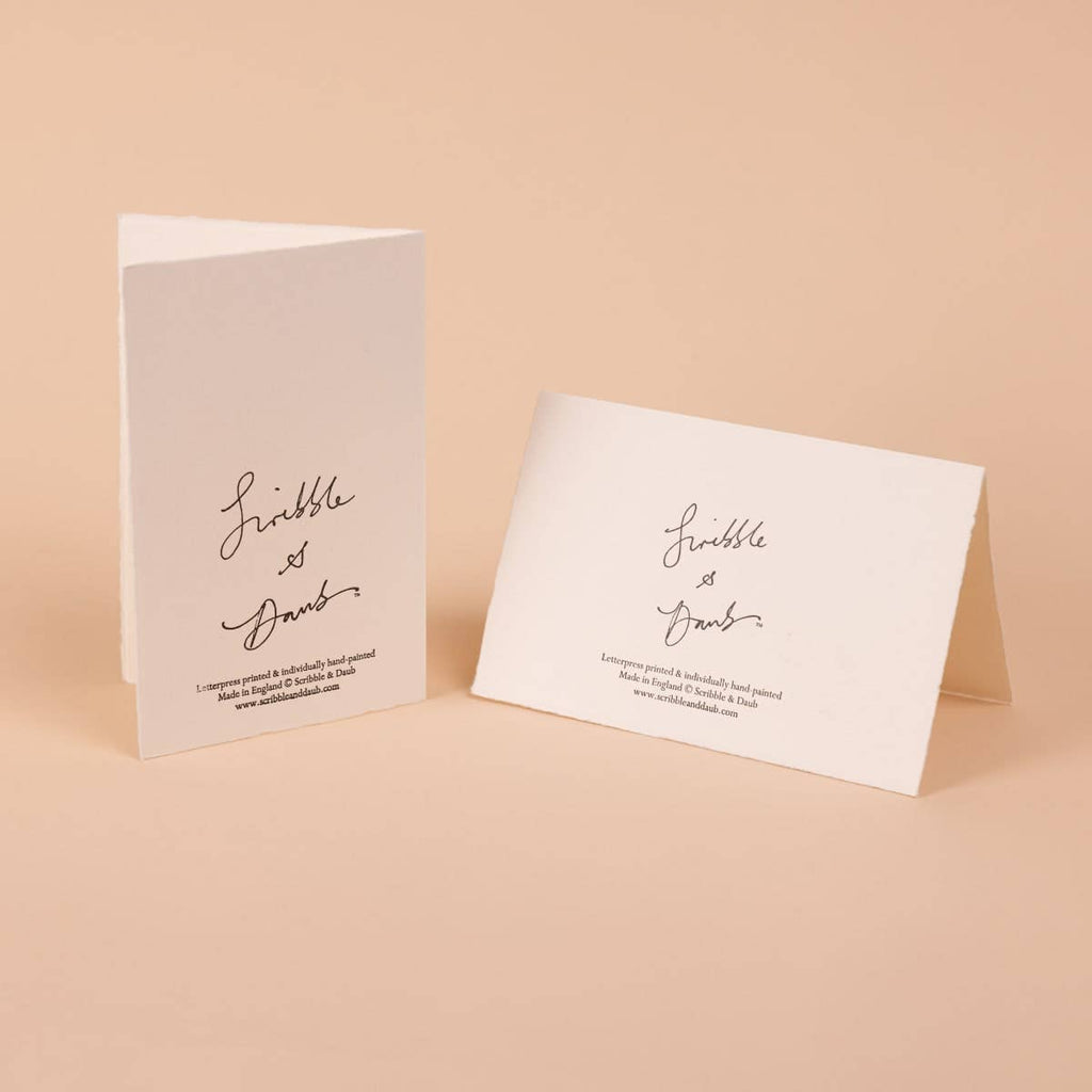 Scribble & Daub-kort med den håndskrevne julehilsen “good yule” i varm orange