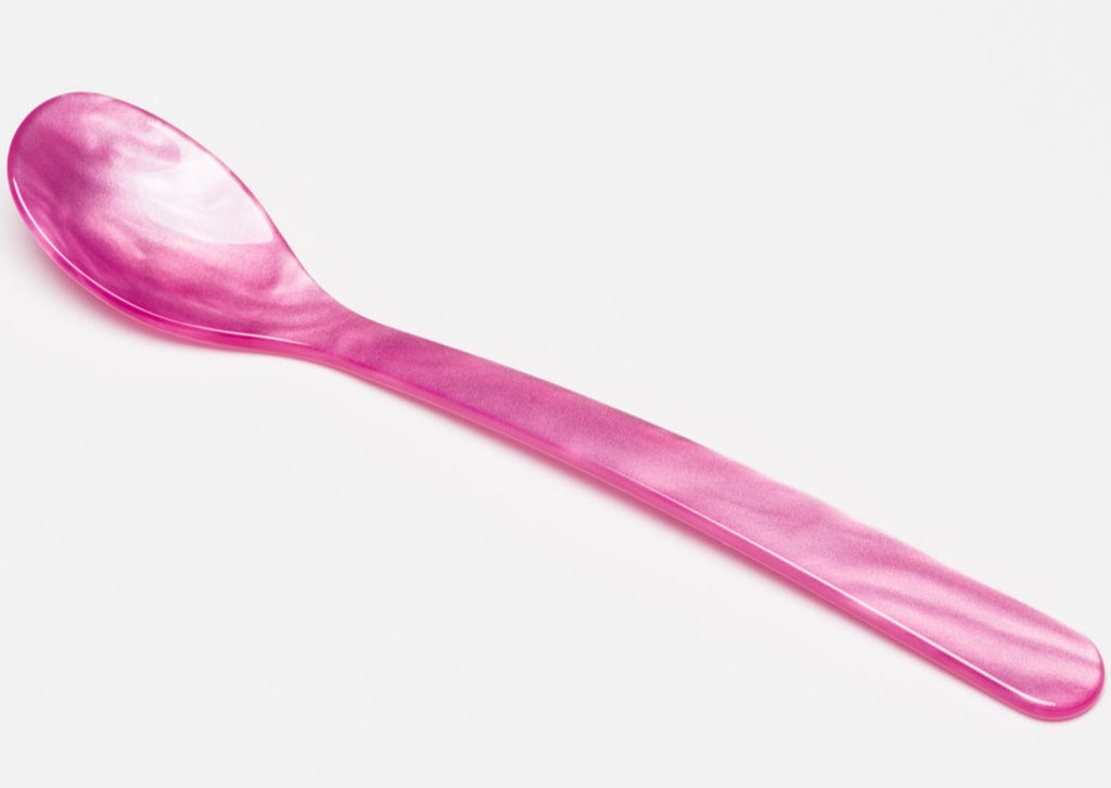 Pink Ske Heim Söhne Lille spoon with a smooth handle and shiny finish, resting on a neutral surface.